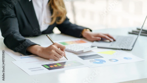Fototapeta Close-up of business woman hands check company finances and earnings and budget with graph on desk in the office.