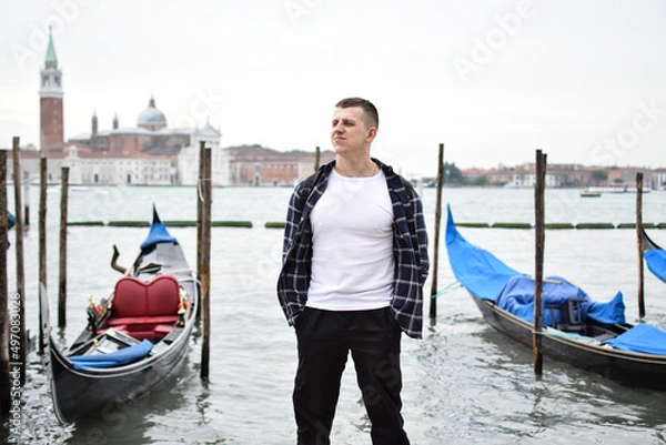 Obraz Young guy tourist near the gondola in Venice
