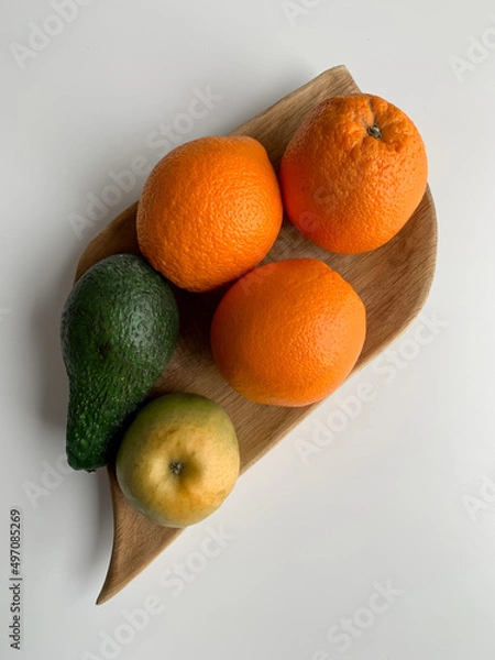 Obraz Fruit on a wooden plate on a white table