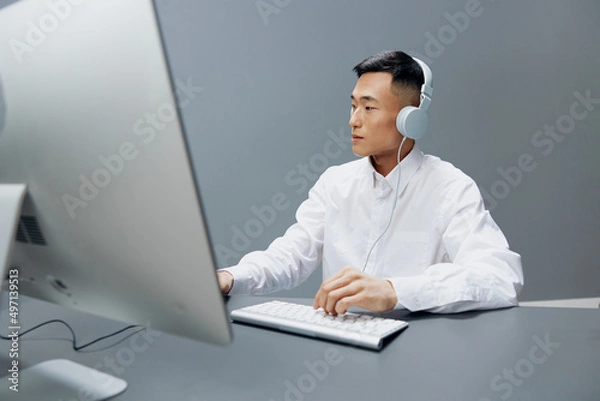 Fototapeta worker in front of the computer with headphones emotions Lifestyle work