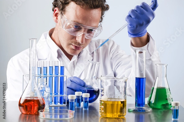 Obraz chemist working at a lab bench with various solutions