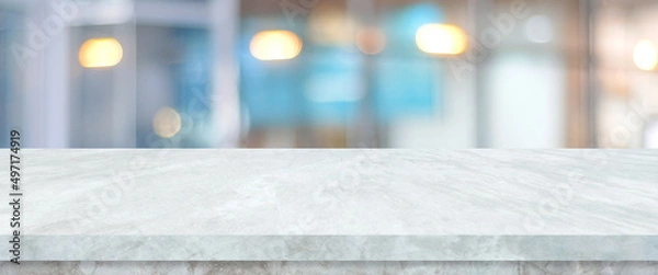 Obraz Empty white table top, counter, desk over blur perspective store with bokeh light background, White marble stone table, shelf and blurred shop for food, product display mockup, template backdrop