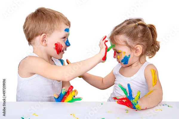 Fototapeta Small children draw on each other with finger paints on a white background