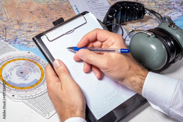 Fototapeta The pilot is preparing to fly. Route calculation, flight plan preparation, checklist checks. The concept of a flight school and an airline.