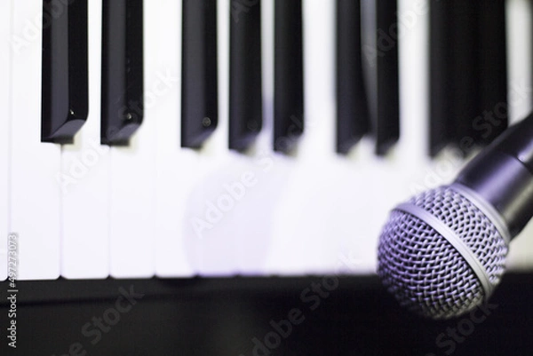 Fototapeta Microphone over piano keys in dim light