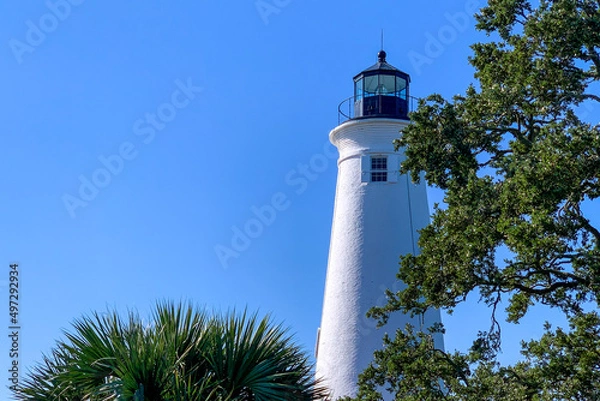 Obraz Historic coastal lighthouse with foreground trees