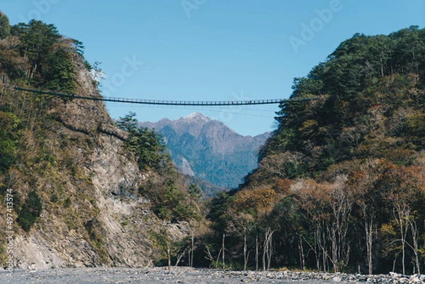 Fototapeta Nenggao mountain covered with snow and Aowanda Suspension Bridge above the riverbank of Wanda North Fork Hot Spring, Taiwan