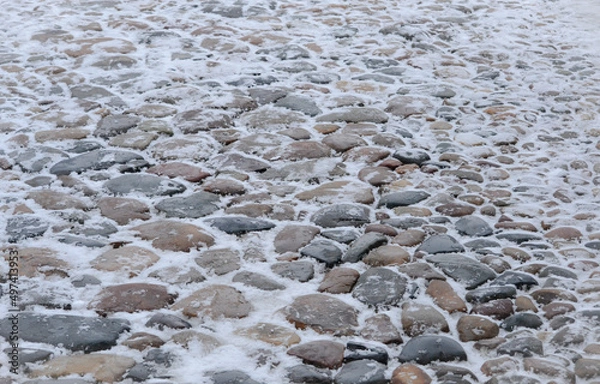 Fototapeta Close up cobblestone pavement in winter time. Textured, surface.