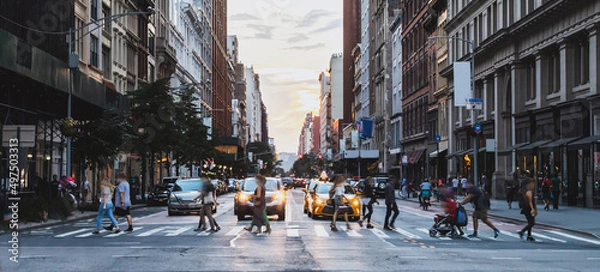 Fototapeta Busy street scene with crowds of people walking across an intersection on Fifth Avenue in New York City
