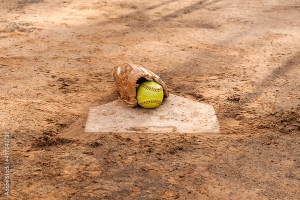Obraz Old softball gloves and old softball balls on the homepage in a softball field.