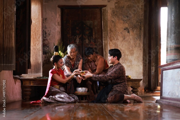 Obraz Songkran festival traditional culture in Thailand , Younger Pouring scented water on the hands of reserved elders and ask for blessing at Choengthar temple.