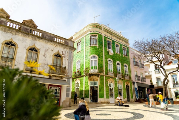 Fototapeta Historical town centre in Lagos, Algarve, Portugal with moving people and a green tiled building.
