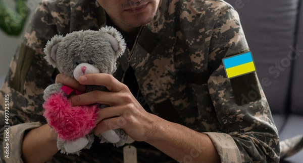 Obraz Ukrainian man warrior dressed in a military pixel uniform the yellow-blue flag of Ukraine