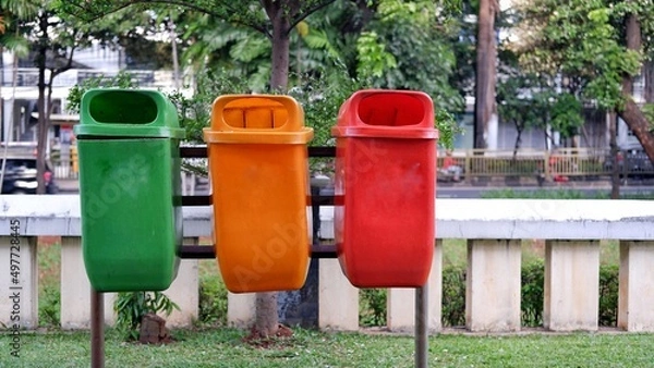 Fototapeta Trash can with three colors. Namely, green for organic waste, orange or yellow for recycling and red for hazardous 