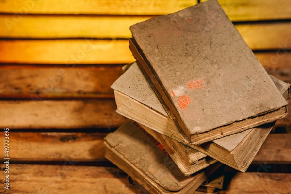 Fototapeta Top view of stack of dusty, old books on wooden board. Close up of a pile of vintage books