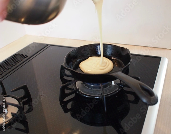 Obraz 鉄製のフライパンにパンケーキの生地を流し込む工程