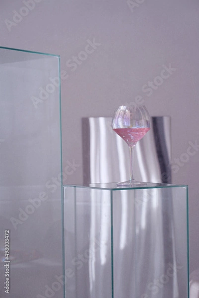 Fototapeta Glass goblet with a drink on a glass table