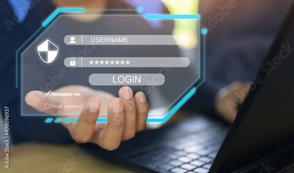 Fototapeta A man holding a virtual screen in his hand indicates a login to enter a cyber computer system or cybersecurity in accordance with ISO 27001 and 27002.