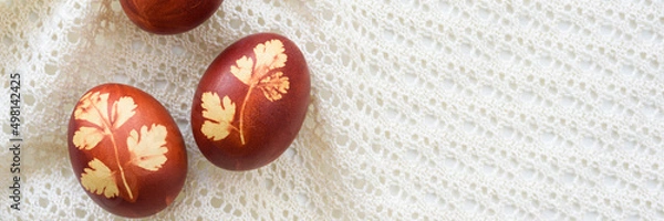 Obraz Panoramic photo. Top view of easter eggs, lying on lace tablecloth. Traditional and rustic arrangement. Easter concept.
