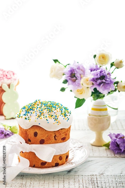 Fototapeta Traditional Easter sweet bread or cakes with white icing and sugar decor and quail eggs over white wooden table. Various Spring Easter cakes. Happy Easter day. Christian traditions.  Top view.