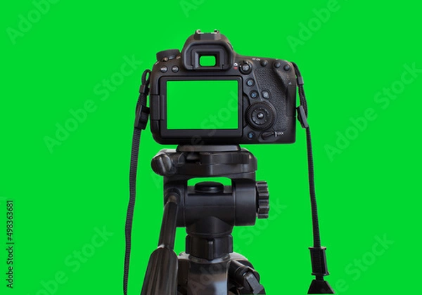 Fototapeta Dslr camera with empty screen on the tripod, isolated on green background. Green screen camera.