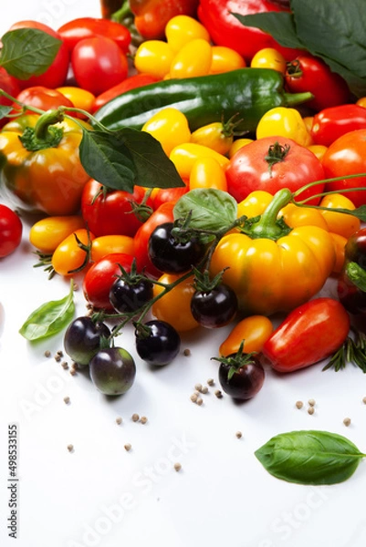 Obraz Assorted tomatoes and vegetables isolated on white background. Photo for your design.