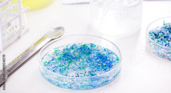 Fototapeta hand of traces of plastic and microplastic in petri dish, analyzed in laboratory, study of environmental problem