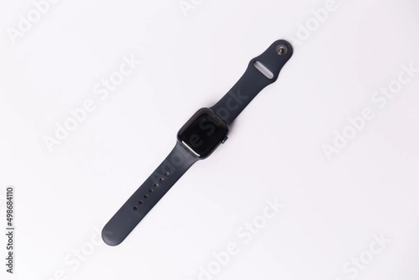 Fototapeta A smartwatch isolated on a white background. Black smartwatch with insulated wrist with open strap. Modern design for high-tech smartwatch and sport technology concept. Close up. Top side view.