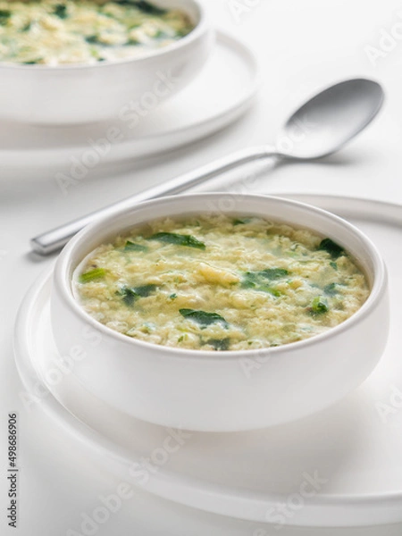Fototapeta Fresh homemade Italian soup Stracciatella alla Romana with spinach. Egg drop soup. Vertical. Selective focus. High key.