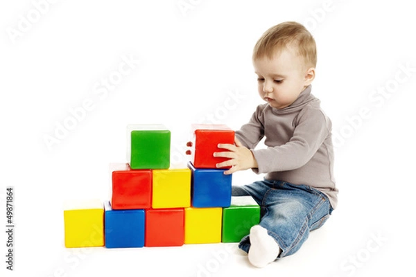 Fototapeta child playing with toy cubes, isolated on white