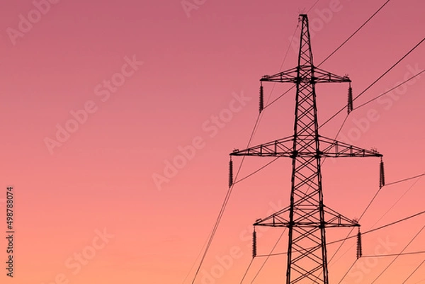 Fototapeta Background, view or scene of steel tower of electric main or electricity transmission line with the wires silhouette on yellow, orange and red background of sunset or sunrise sky