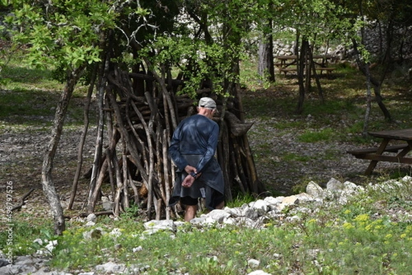 Obraz Vieil homme de dos devant une cabane