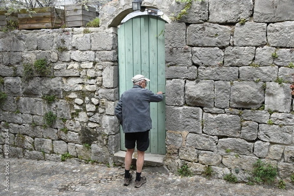 Obraz Vieil homme devant une porte verte