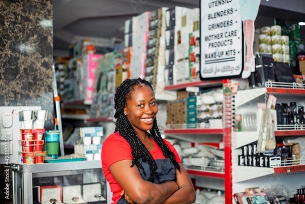 Obraz Shot of a cheerful black african millennial woman posing proudly at camera with arm crossed.