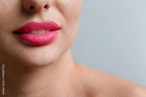Fototapeta Closeup view of woman with beautiful lips on light grey background. Space for text