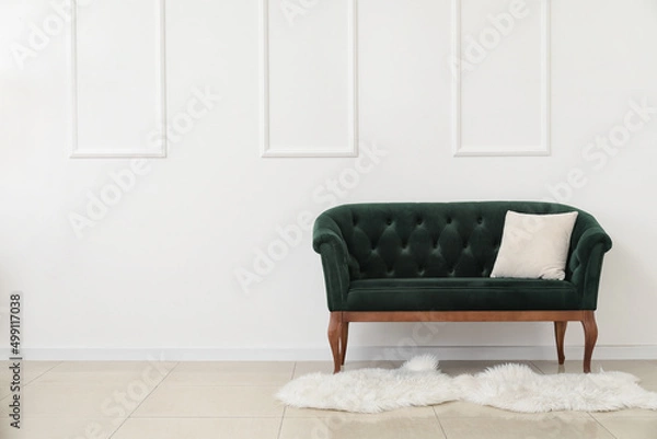 Fototapeta New green sofa with pillow near white wall