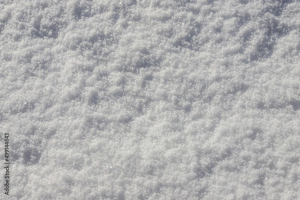 Fototapeta Beautiful winter background with snowy ground. Natural snow texture. Wind sculpted patterns on snow surface