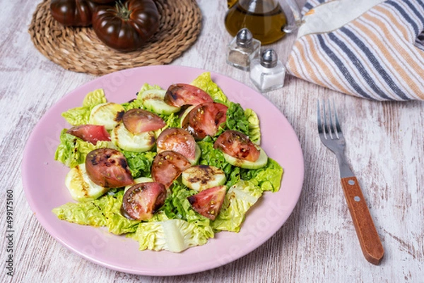 Obraz Lettuce, cucumber and raf tomato salad, seasoned with olive oil, salt and balsamic vinegar.