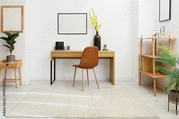 Fototapeta Stylish workplace with comfortable chair and gladiolus flowers