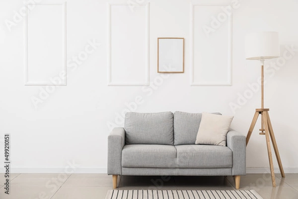 Fototapeta New sofa and modern lamp near white wall