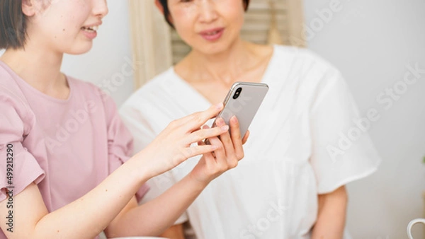 Fototapeta スマートフォンを使う母と娘