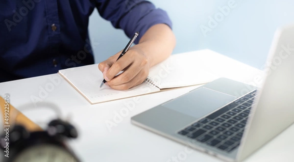Fototapeta Corporate businessman working at office desk, his is working with a laptop and connecting with a digital touch screen tablet. Business objects of engineers office with construction engineer architect.