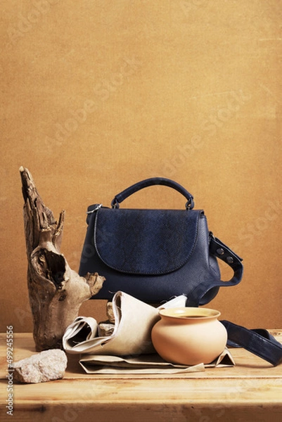 Fototapeta Still life with a blue women's handbag and objects made of natural materials. Eco leather handbag and objects on a wooden background.