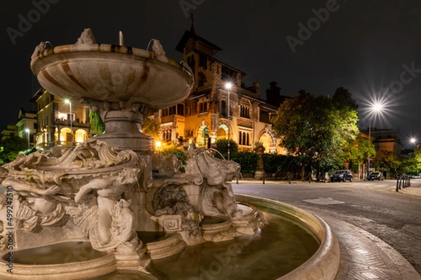Fototapeta Neighborhood coppede detail of the fountain of the frogs at night after the restoration. The street lights illuminate the little fairy house. Center of Rome Trieste district. Italy.