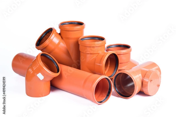 Obraz Plumbing fixtures and orange piping parts plastic fittings isolated on a white background