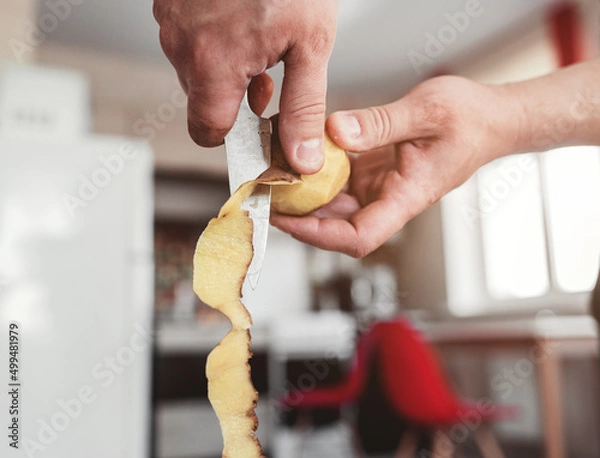 Fototapeta  chef peeling potatoes