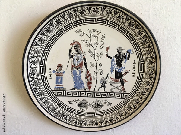 Fototapeta Rhodes, Greece - July 23, 2018: Plate with the image of the goddesses of Greek mythology Athena and Aphrodite. Close-up