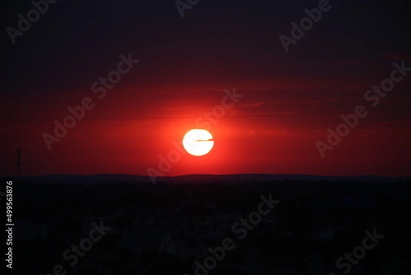 Fototapeta red sunset in summer in the city.
