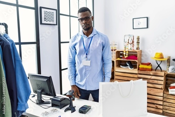 Fototapeta Young african man working as manager at retail boutique depressed and worry for distress, crying angry and afraid. sad expression.