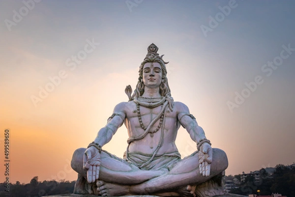 Fototapeta hindu god lord shiva statue in meditation posture with dramatic sky at evening from unique angle